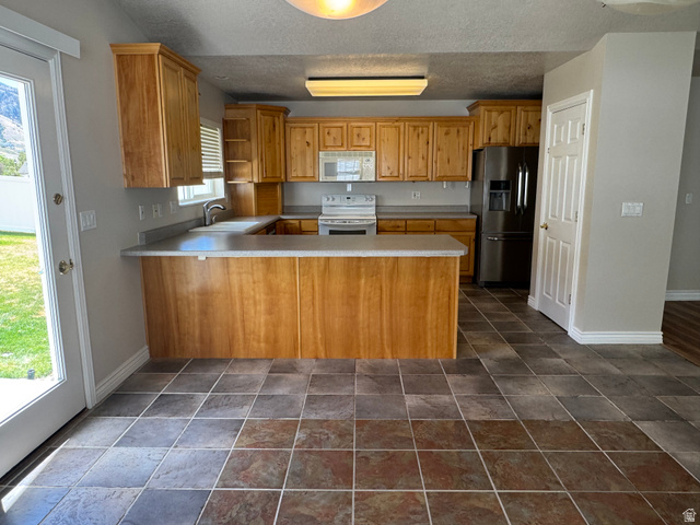 88 Canterbury Lane Logan, UT 84321 - Photo 3 of 37 Kitchen with wood cabinetry, light countertops, and tile flooring