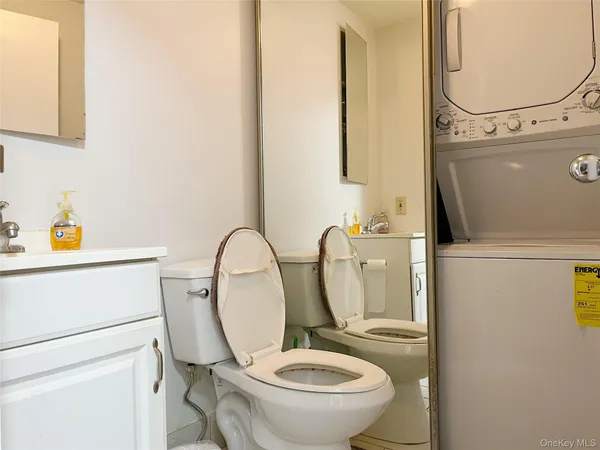 a kitchen with stainless steel appliances granite countertop a stove top oven a sink a dining table and chairs with white cabinets