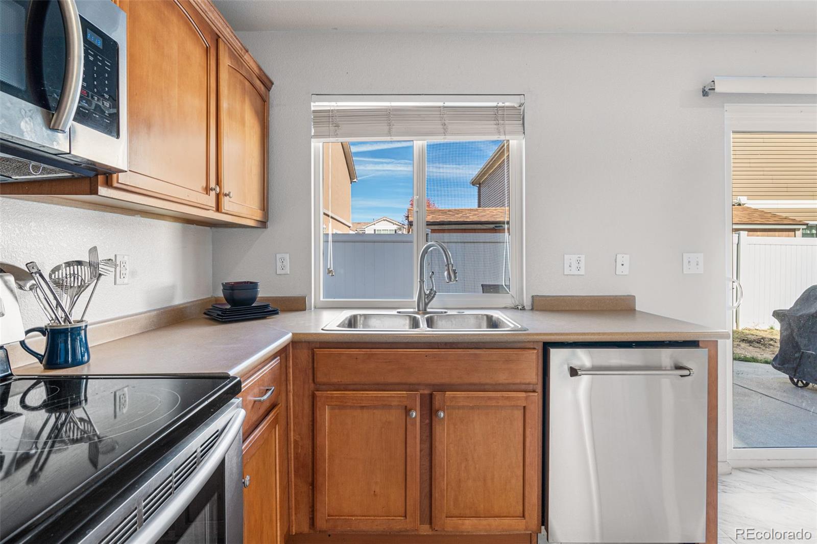 19525 Robins Drive Denver, CO 80249 - Photo 16 of 44 a kitchen with stainless steel appliances granite countertop a sink stove and cabinets