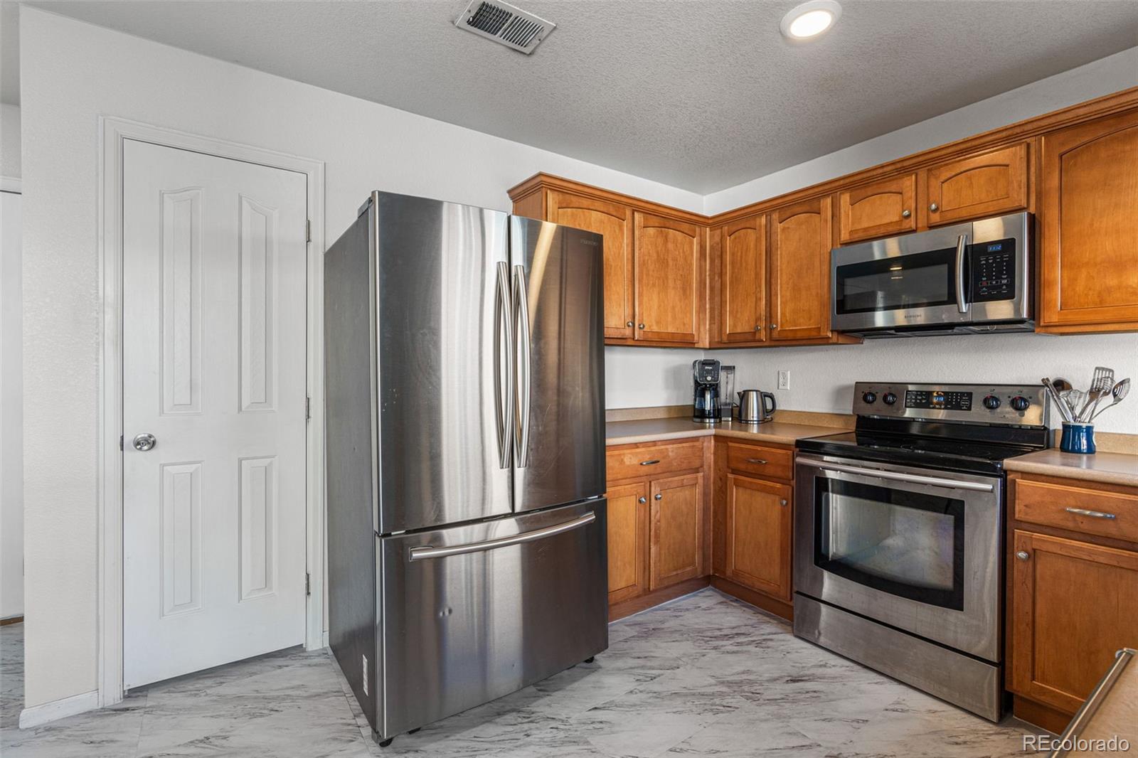 19525 Robins Drive Denver, CO 80249 - Photo 17 of 44 a kitchen with stainless steel appliances granite countertop a stove a refrigerator and a microwave
