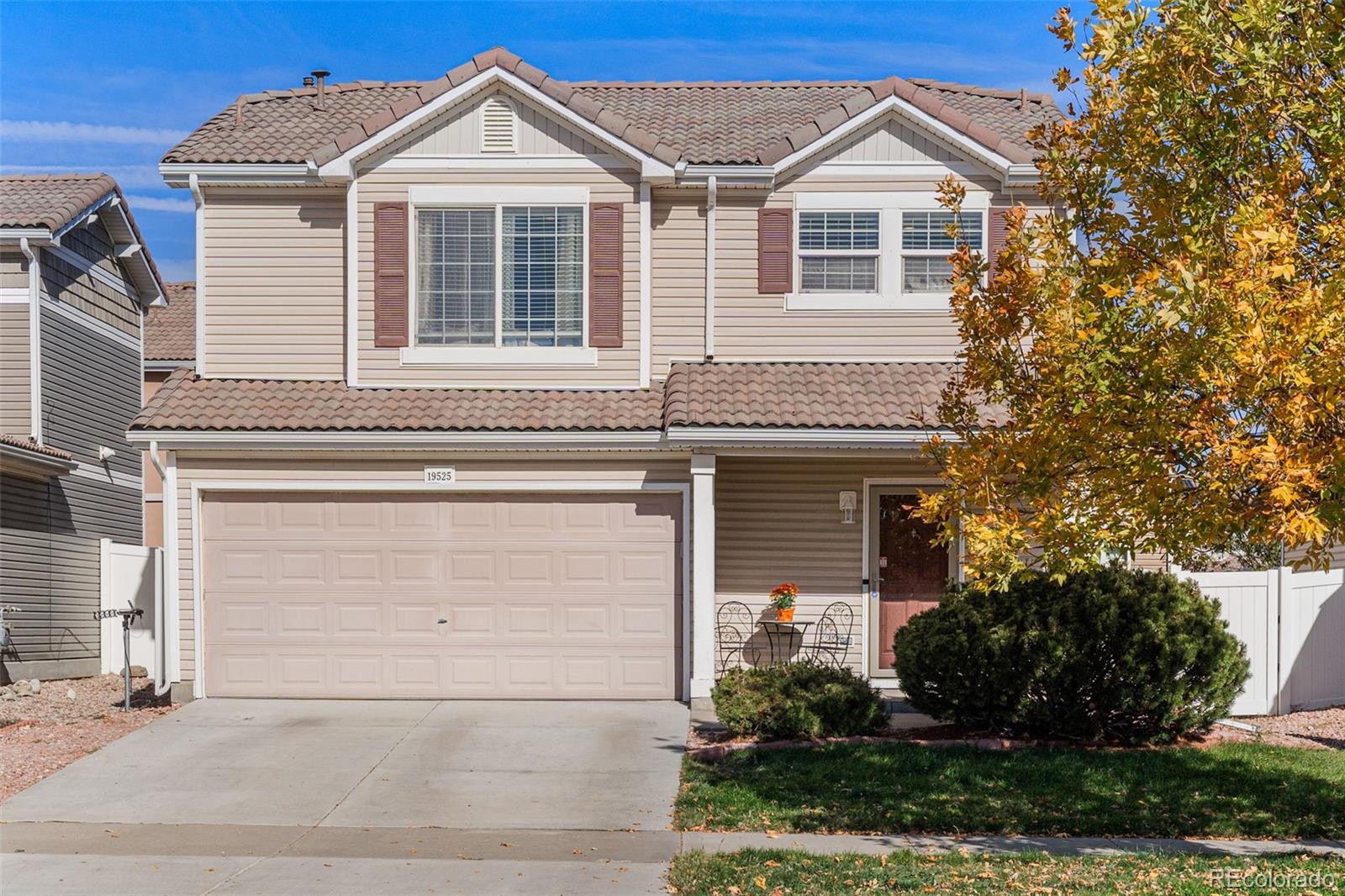 19525 Robins Drive Denver, CO 80249 - Photo 2 of 44 a front view of a house with a yard and garage