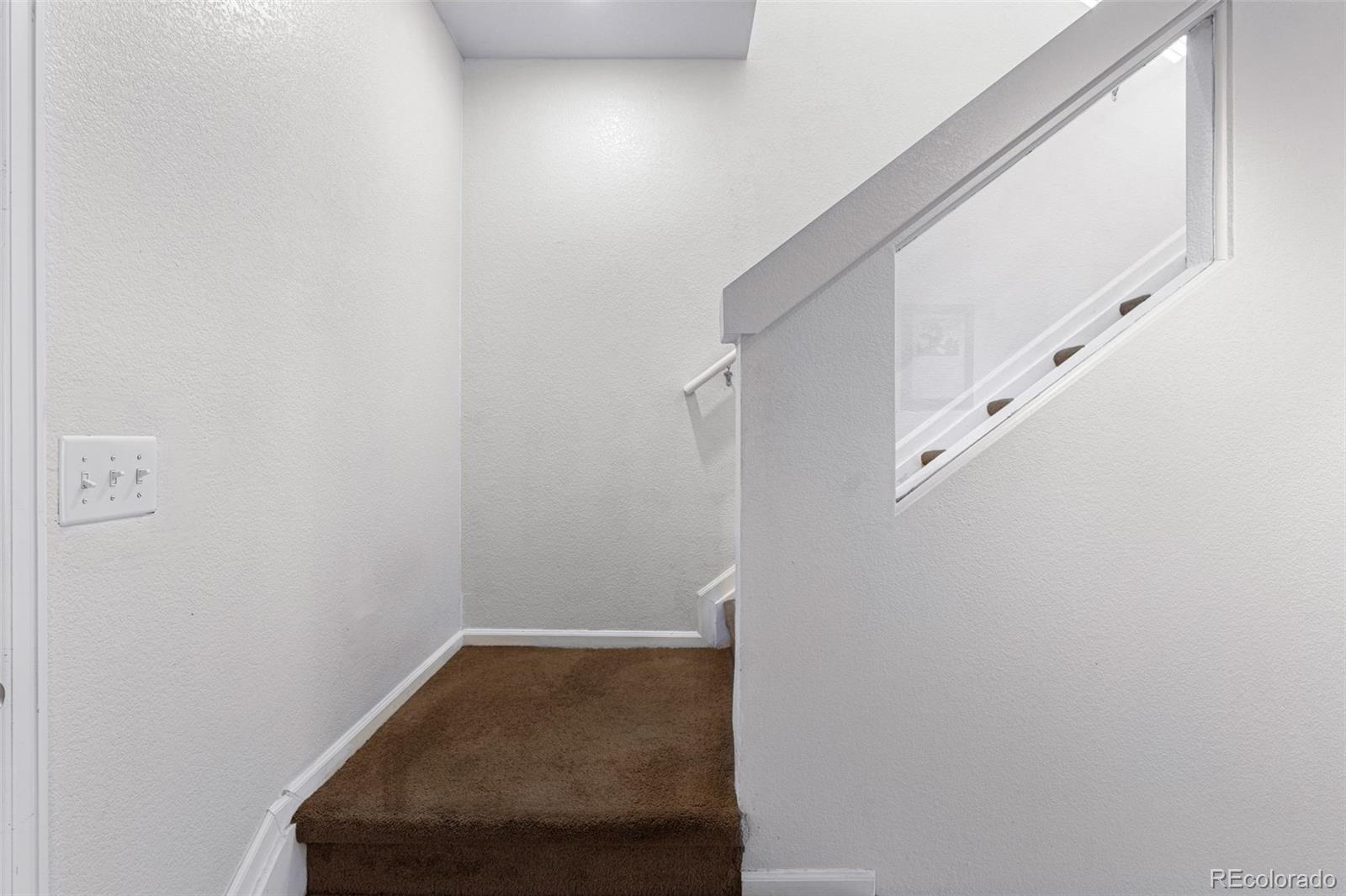 19525 Robins Drive Denver, CO 80249 - Photo 21 of 44 a view of staircase with white walls and white door