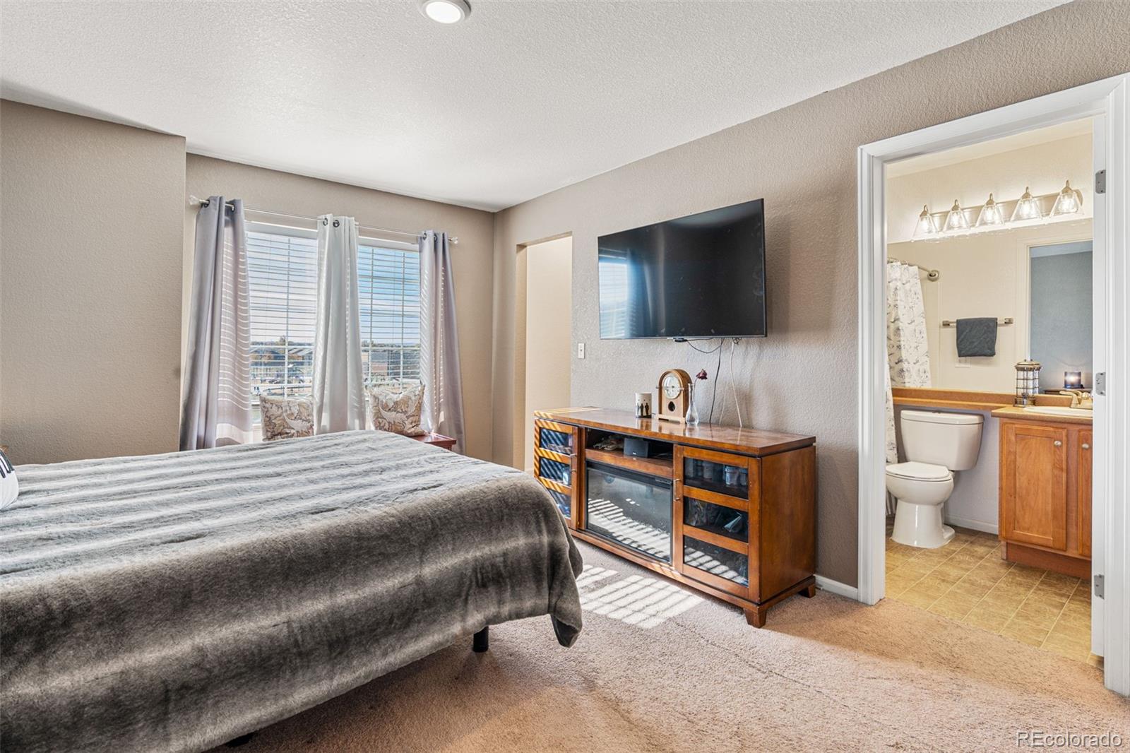 19525 Robins Drive Denver, CO 80249 - Photo 27 of 44 a bedroom with a bed and a flat screen tv