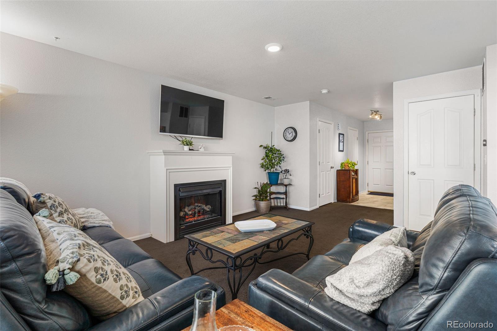 19525 Robins Drive Denver, CO 80249 - Photo 9 of 44 a living room with furniture a fireplace and a flat screen tv