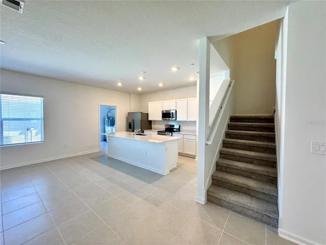 a view of a kitchen with furniture and staircase