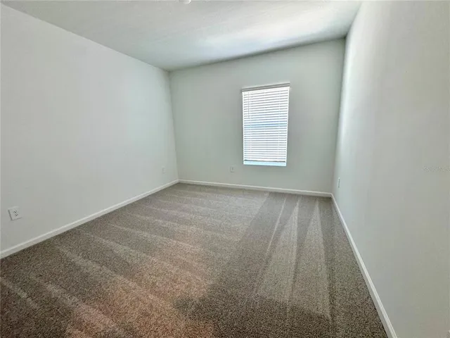 an empty room with a hardwood and windows