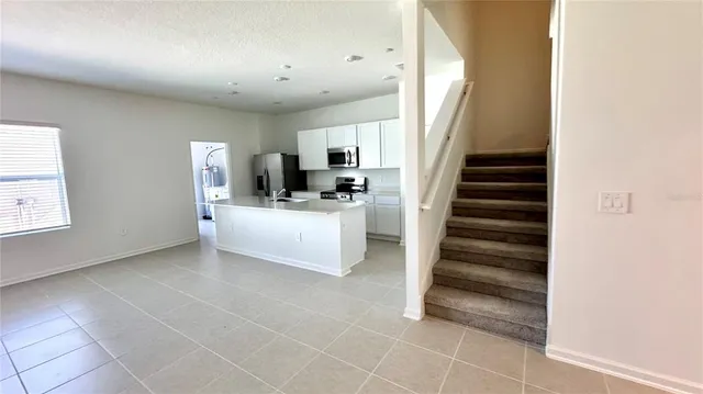 a view of a livingroom with furniture and stairs