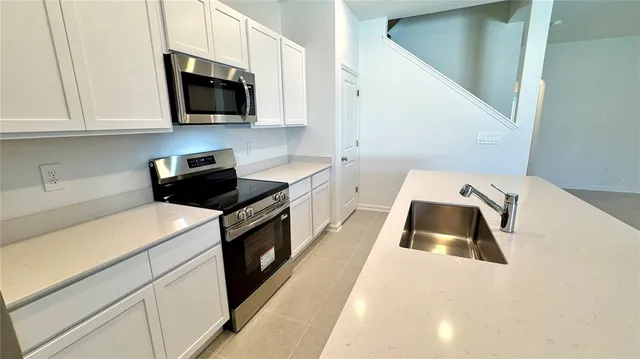 a kitchen with a sink a stove and cabinets