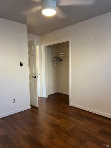 an empty room with wooden floor and closet