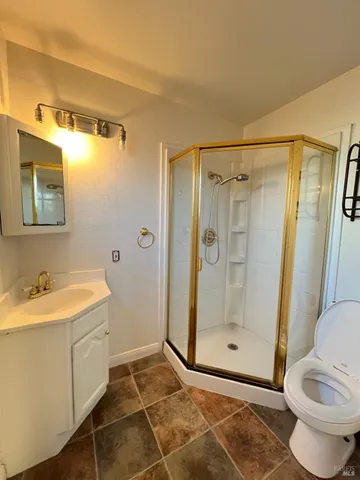 a bathroom with a granite countertop sink toilet and shower