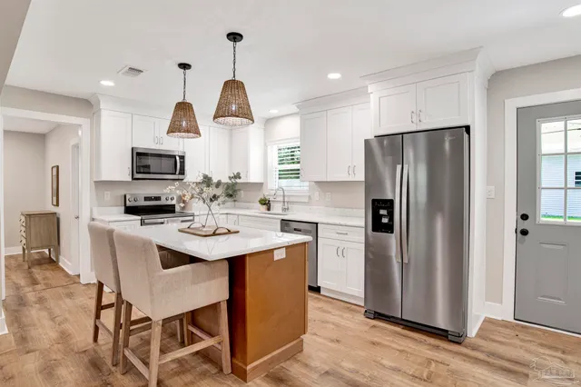 a kitchen with stainless steel appliances a refrigerator a stove a microwave and island