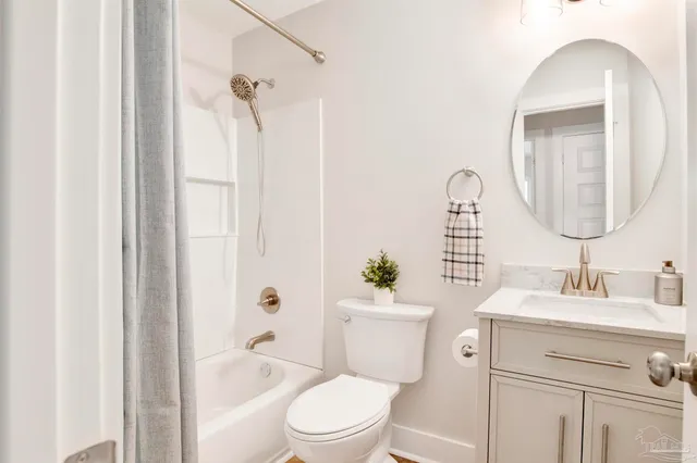 a bathroom with a granite countertop toilet a sink and a mirror