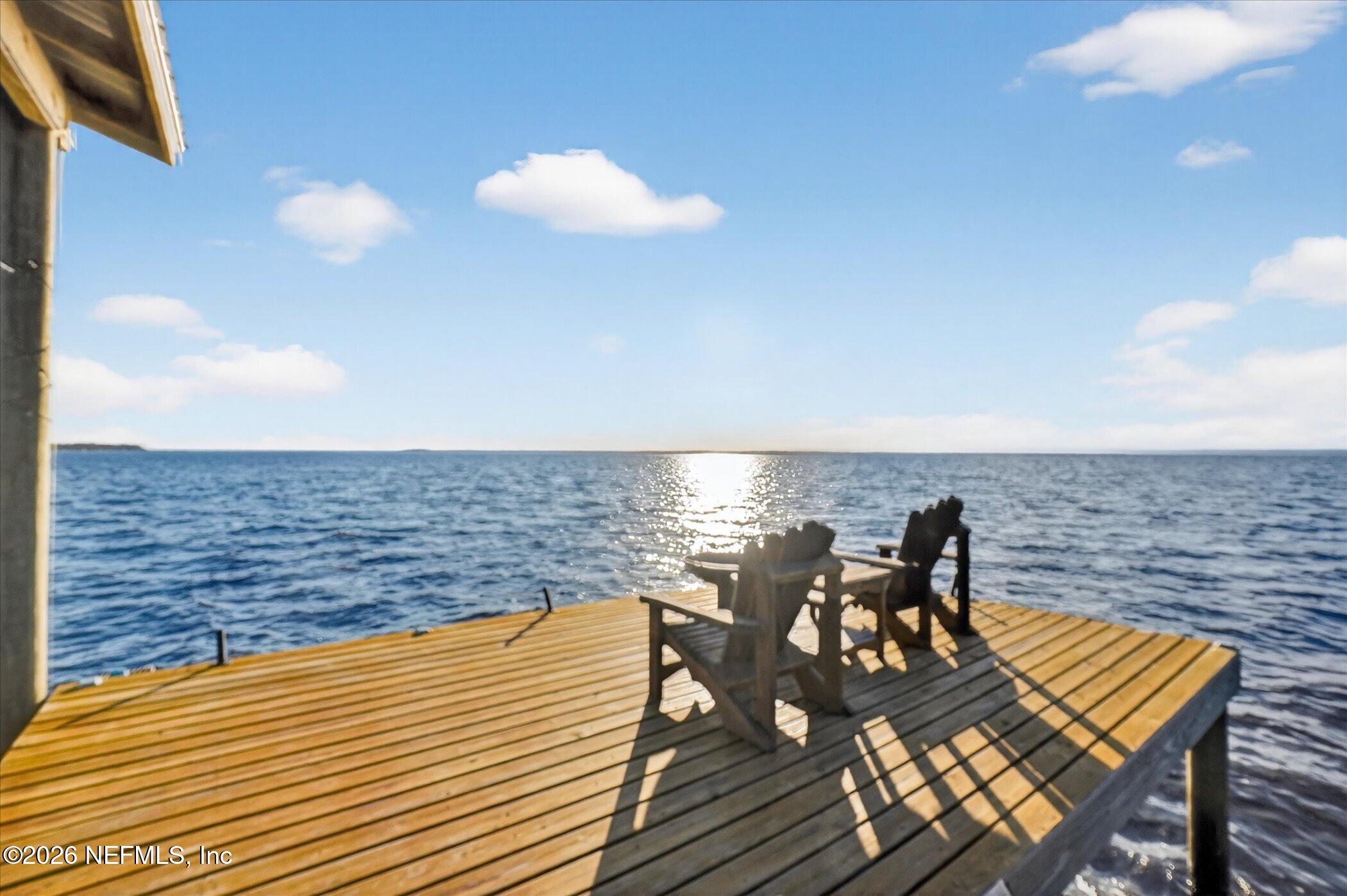 a view of a roof deck with dining table and chairs