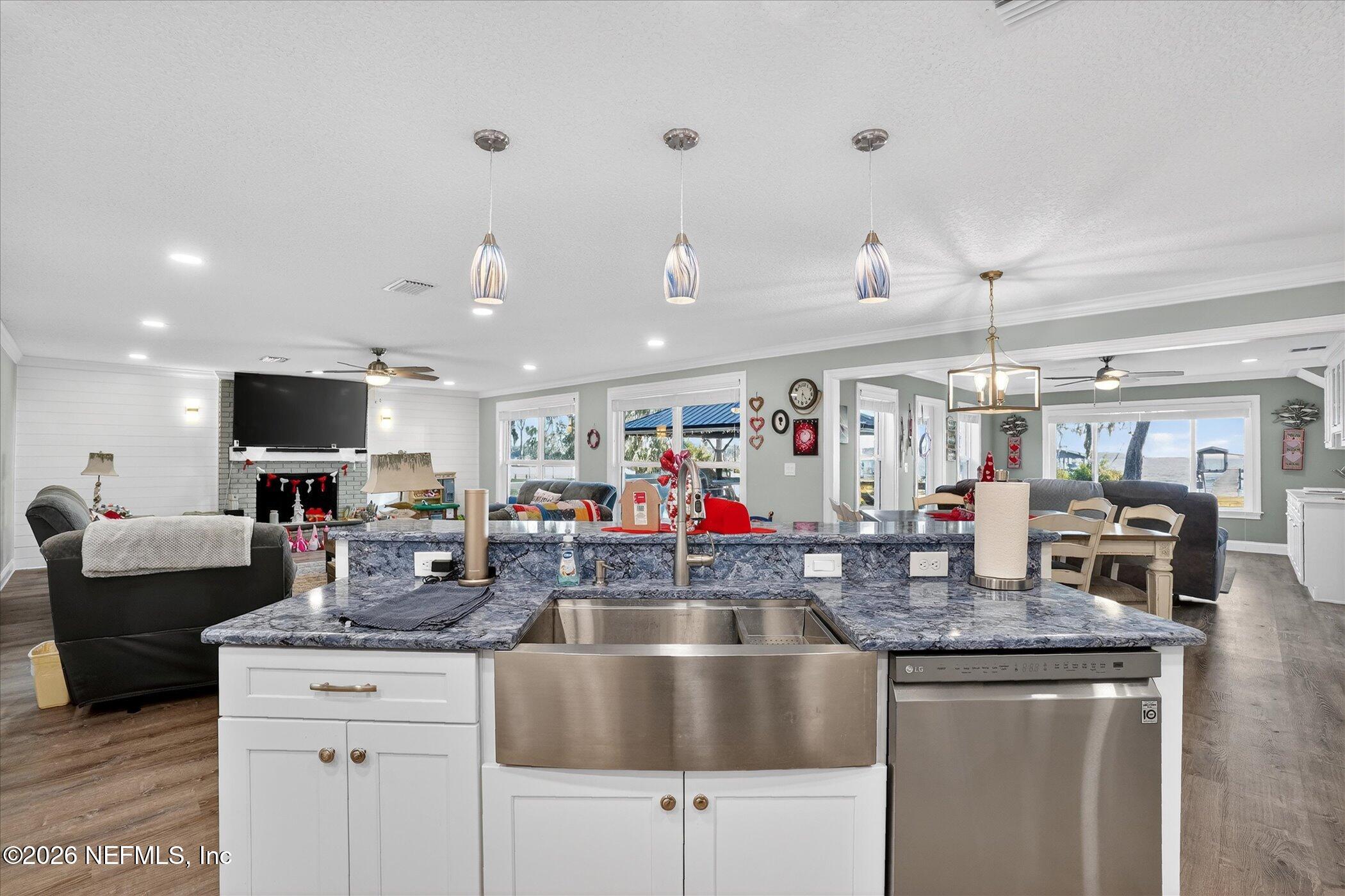 6447 Jack Wright Island Road St. Augustine, FL 32092 - Photo 12 of 37 a kitchen with stainless steel appliances granite countertop a sink dishwasher a flat tv screen and couches