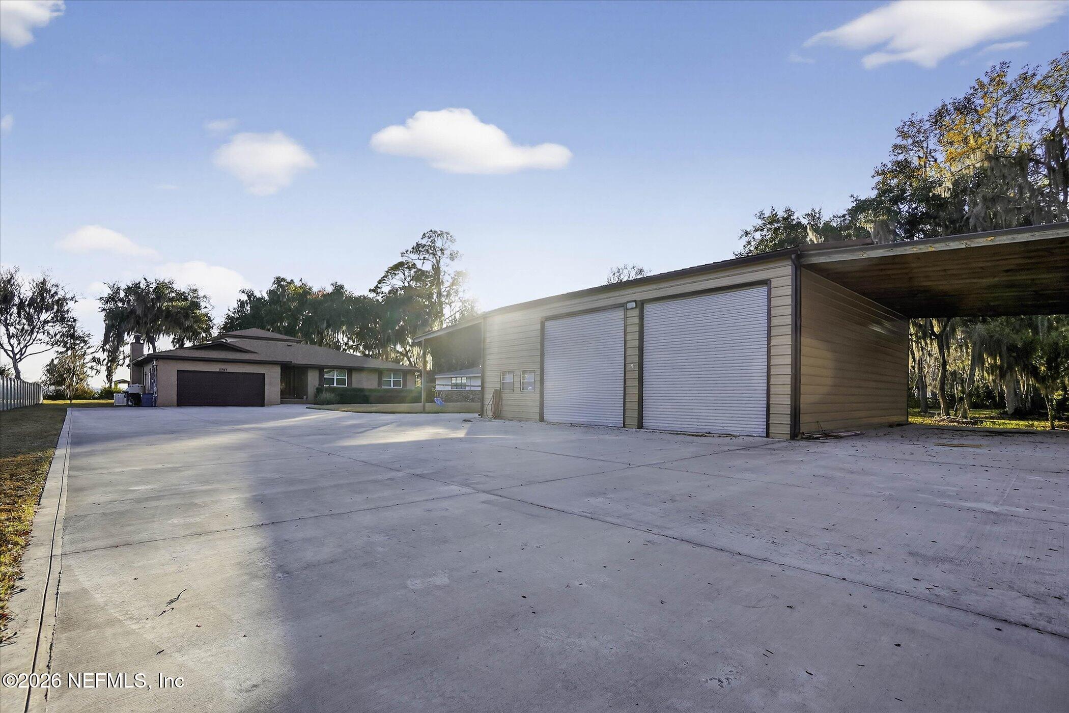 6447 Jack Wright Island Road St. Augustine, FL 32092 - Photo 4 of 37 a view of a house with a yard and a garage