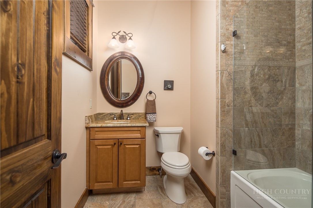 115 Passionflower Trail Boone, NC 28607 - Photo 28 of 50 a bathroom with a granite countertop toilet a sink and a bathtub