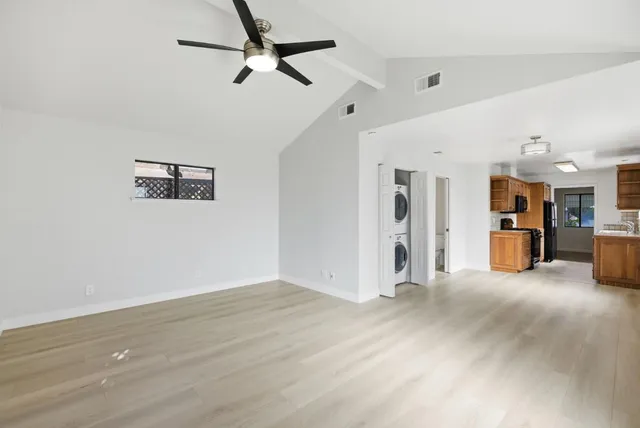 a view of a big room with wooden floor and ceiling fan