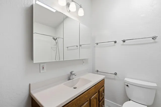 a bathroom with a sink a toilet and shower