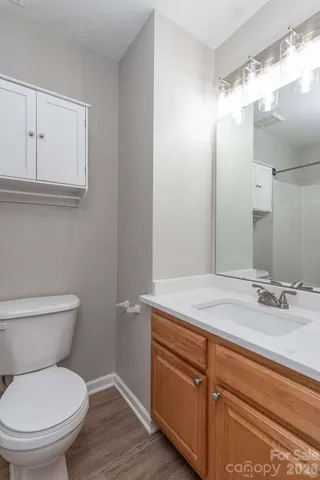 a bathroom with a granite countertop toilet sink and mirror