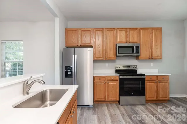 a kitchen with stainless steel appliances granite countertop a sink stove and refrigerator