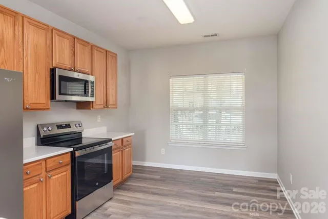 a kitchen with stainless steel appliances granite countertop a stove a sink and a microwave