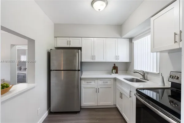 a kitchen with a refrigerator sink stove and cabinets