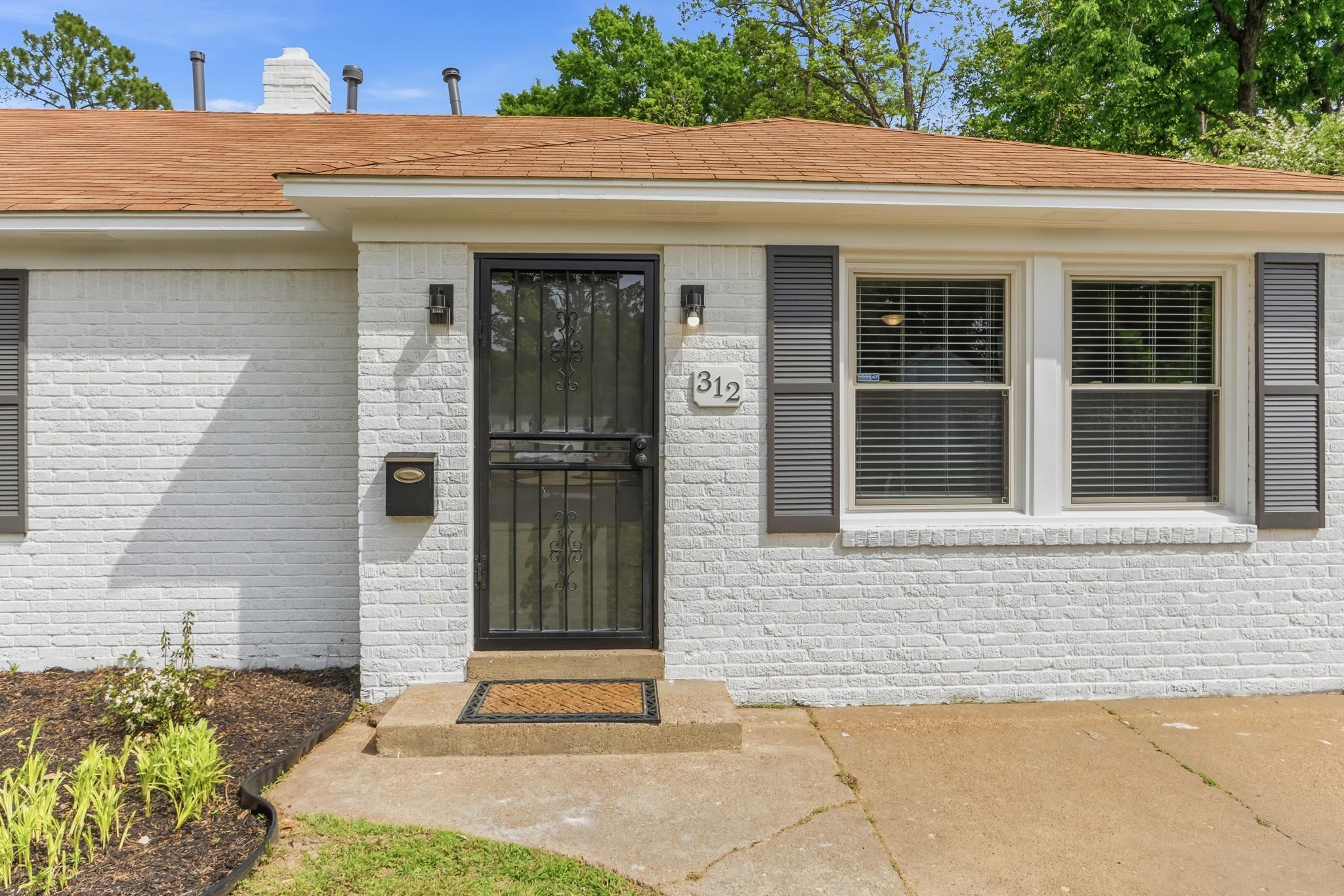 312 Fernway Road Memphis, TN 38117 - Photo 2 of 38 Entrance to property featuring brick siding, roof with shingles, and a chimney