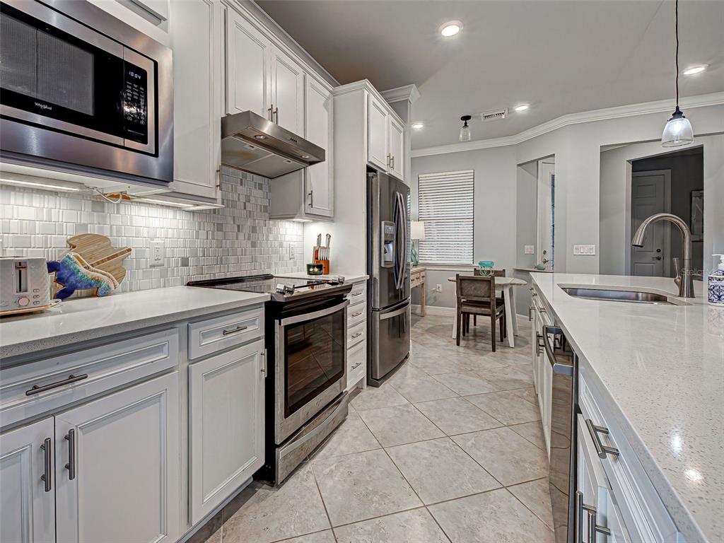 13836 Campoleone Street Venice, FL 34293 - Photo 11 of 99 a kitchen with stainless steel appliances granite countertop a sink and a stove