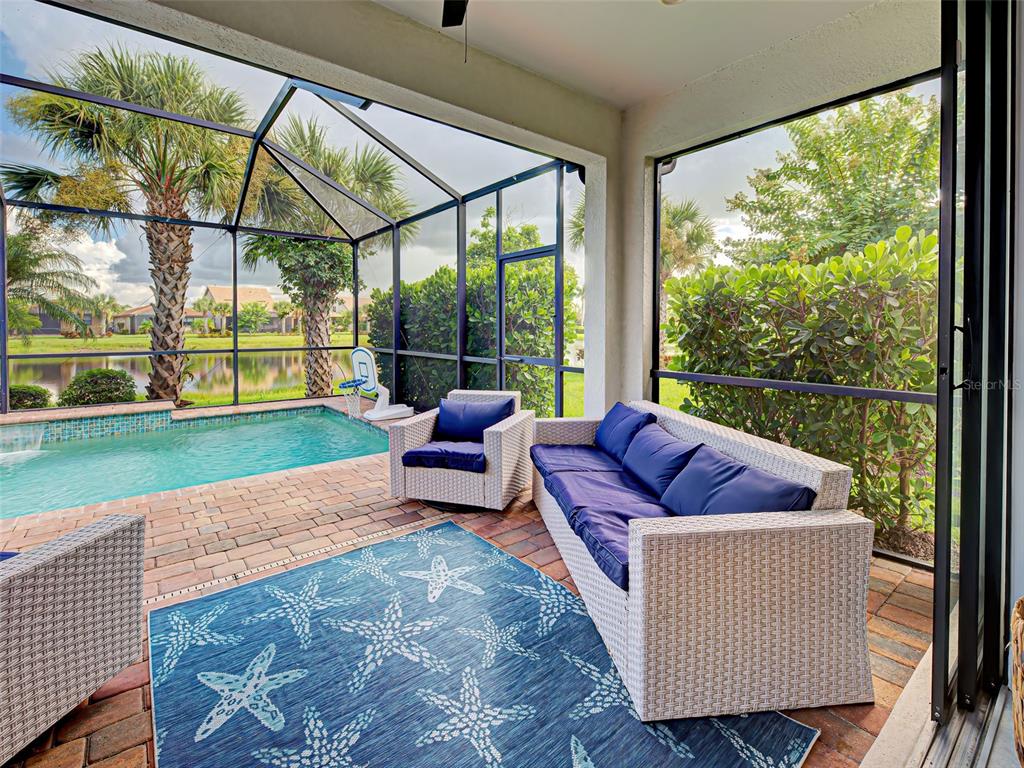 13836 Campoleone Street Venice, FL 34293 - Photo 44 of 99 a living room with couch and a floor to ceiling window