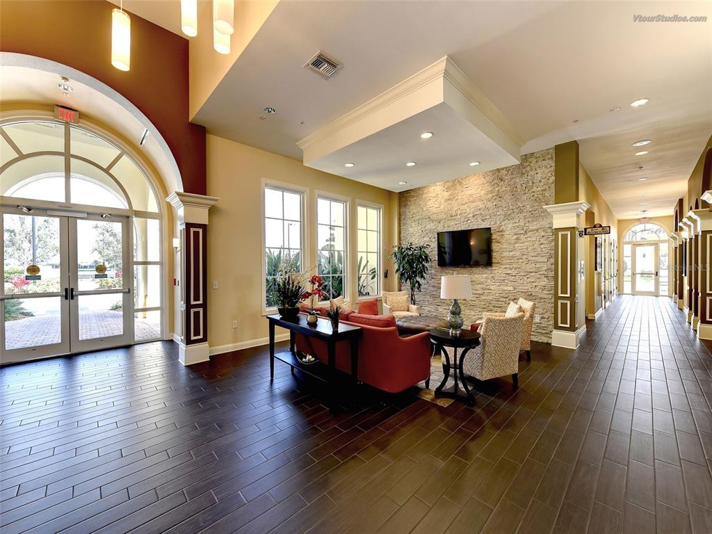 13836 Campoleone Street Venice, FL 34293 - Photo 65 of 99 a living room with couches a flat tv screen and a dining table with wooden floor