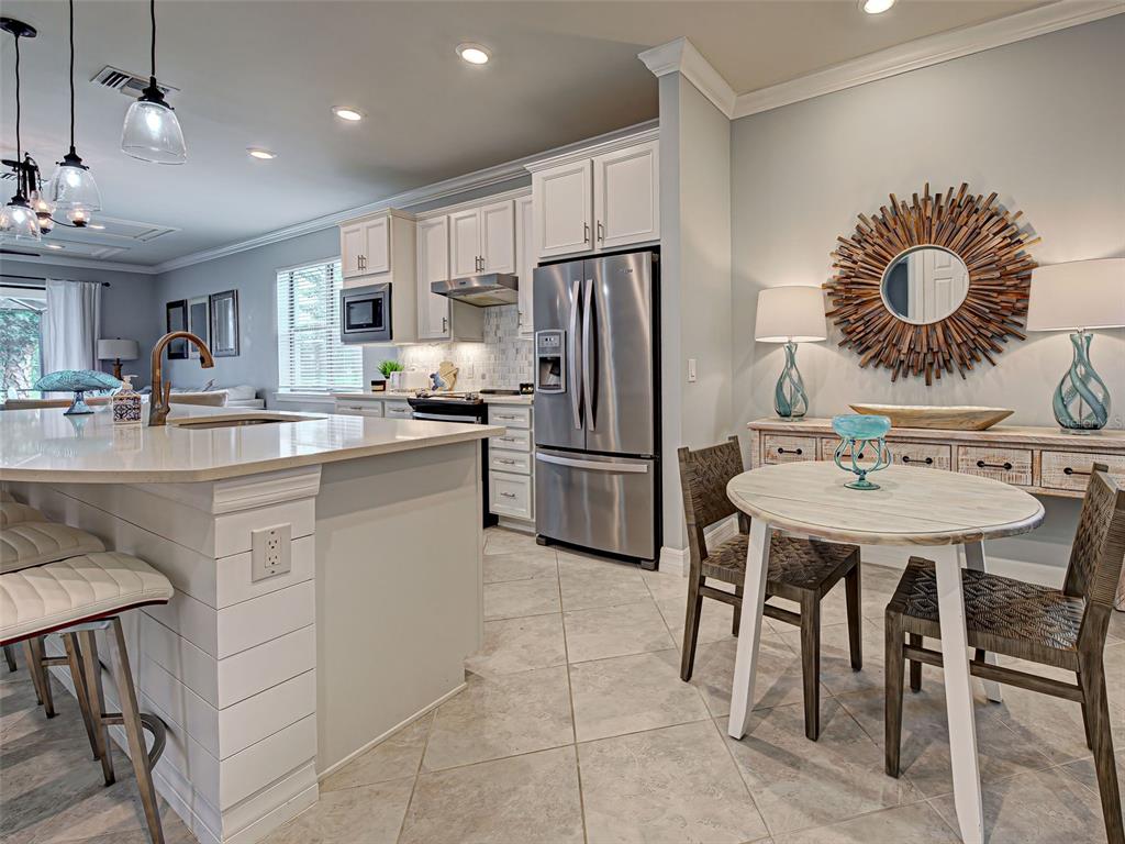 13836 Campoleone Street Venice, FL 34293 - Photo 9 of 99 a kitchen with a dining table and chairs