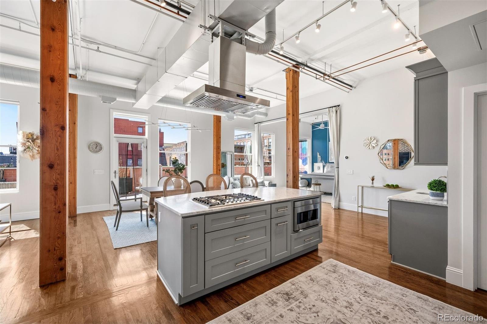 a view of a kitchen with kitchen island granite countertop wooden cabinets and white appliances