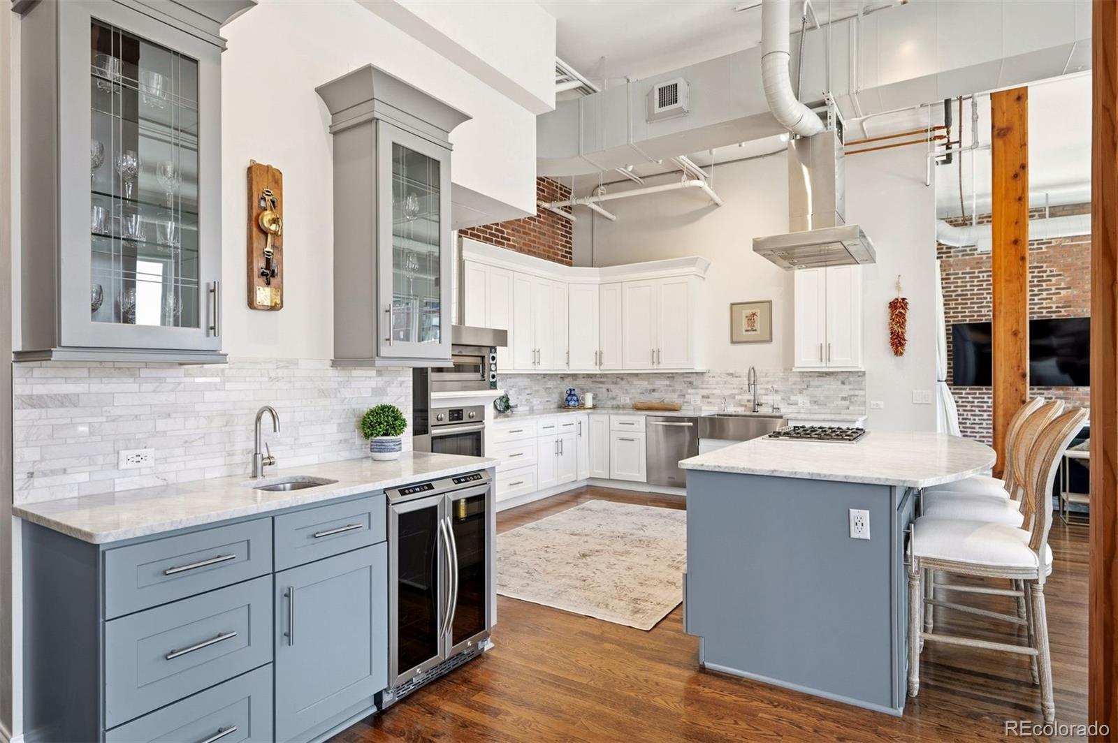 1501 Wazee Street, Unit 4B Denver, CO 80202 - Photo 23 of 49 a kitchen with a sink dishwasher a stove and white cabinets with wooden floor