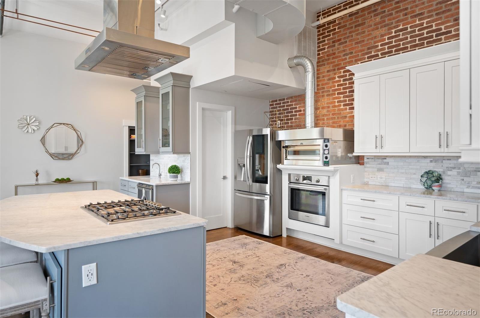 1501 Wazee Street, Unit 4B Denver, CO 80202 - Photo 24 of 49 a kitchen with a stove a sink cabinets and wooden floor