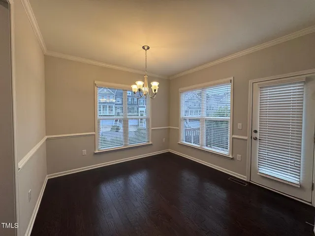 a view of wooden floor chandelier and window in a room