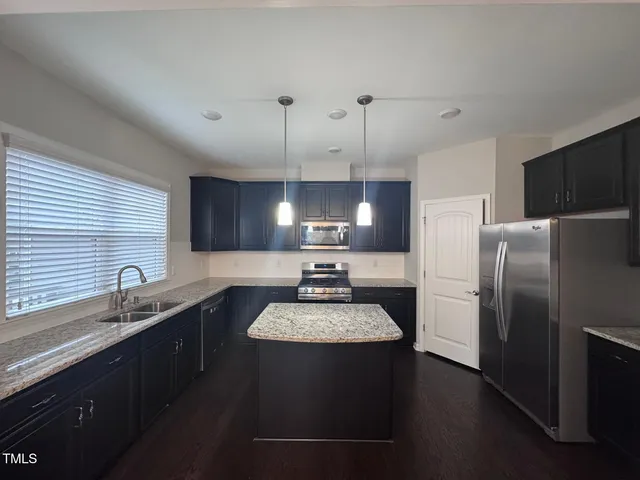 a kitchen with a sink a refrigerator and a stove