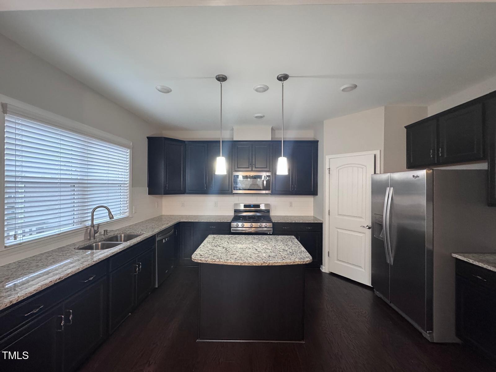 8008 Reedybrook Crossing Apex, NC 27523 - Photo 4 of 27 a kitchen with a sink a refrigerator and a stove