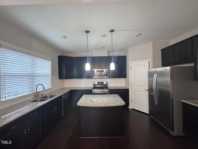 a kitchen with a refrigerator a sink dishwasher a stove and a refrigerator