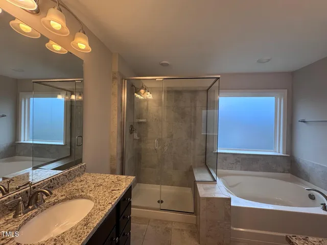 a bathroom with a granite countertop sink mirror and shower