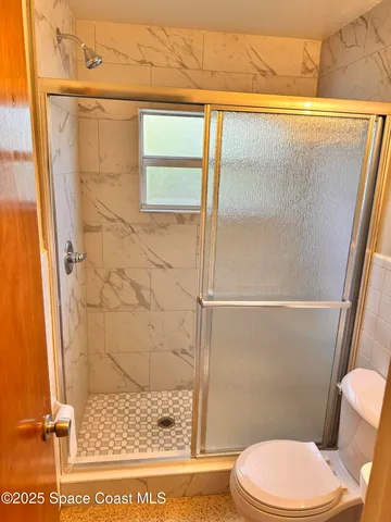 a bathroom with a toilet and a shower