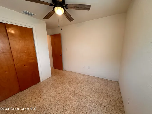 a view of empty room with ceiling fan