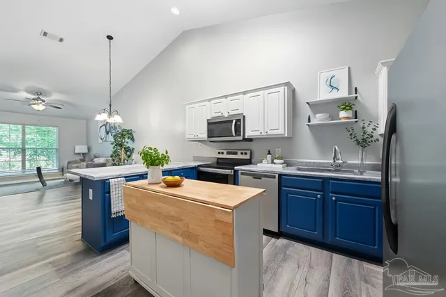 a dining hall with granite countertop a sink dishwasher a stove and a dining table with wooden floor