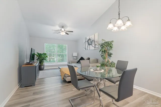 a dining room with furniture potted plants and wooden floor