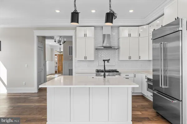 a view of a kitchen with white cabinets and wooden floor