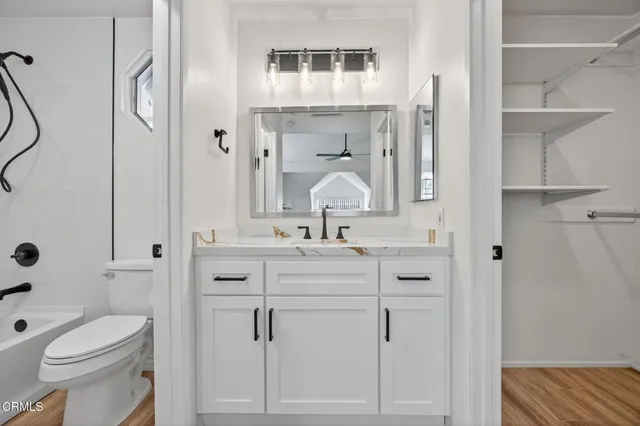 a bathroom with a sink vanity mirror and toilet