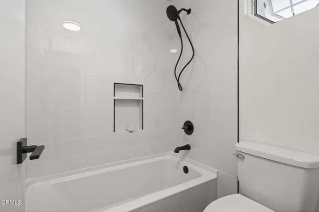 a bathroom with a bath tub with a shower
