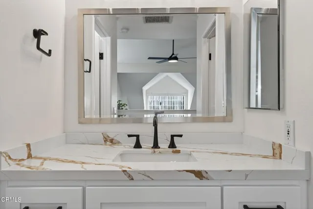 a bathroom with a granite countertop sink mirror and vanity