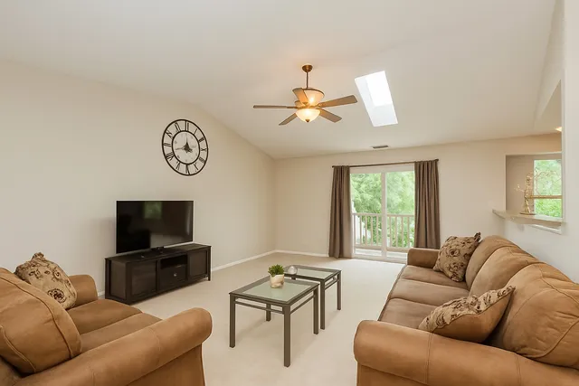a living room with furniture a flat screen tv and a window