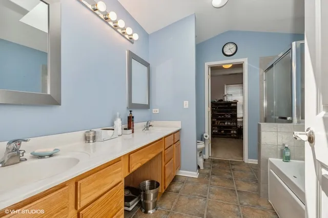 a spacious bathroom with a tub sink and mirror