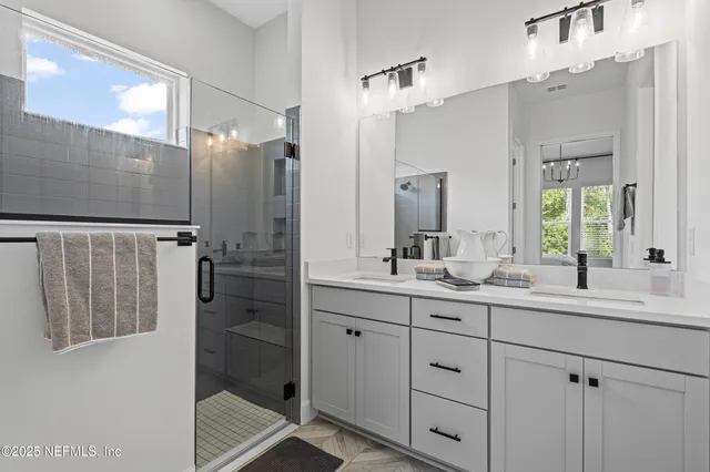 a kitchen with stainless steel appliances a sink a stove a refrigerator cabinets and a window